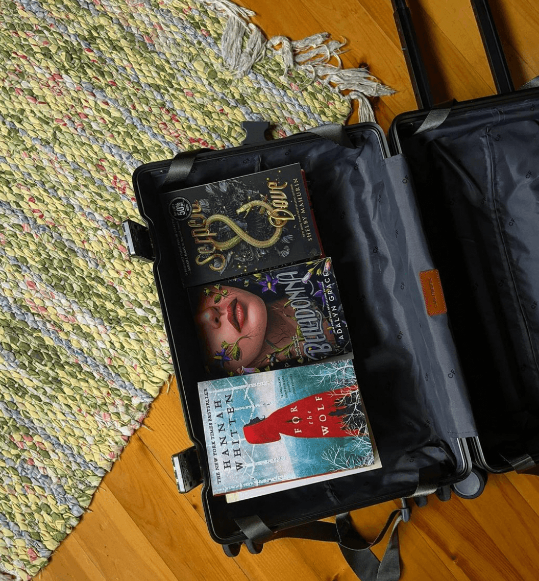 Books stacked in one half of a carry-on suitcase.