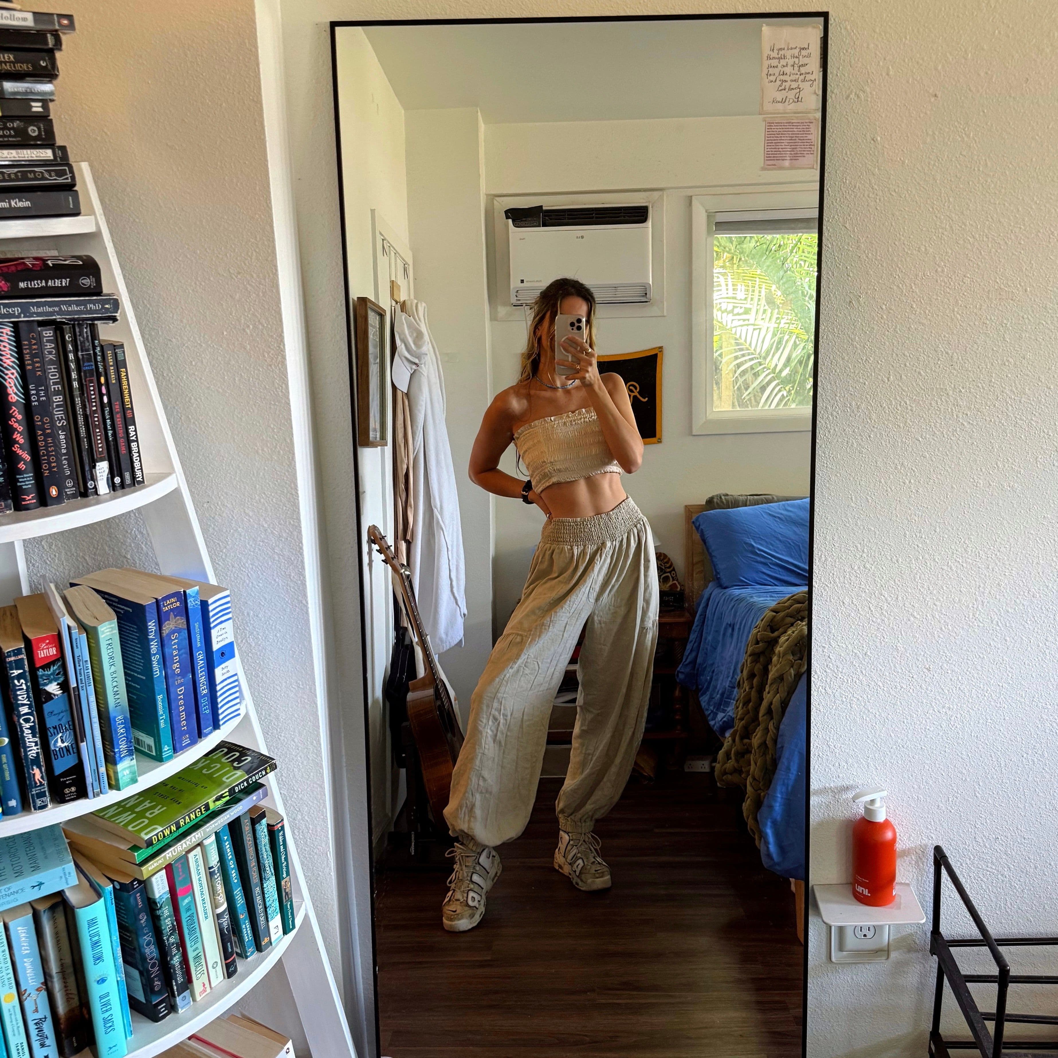 mirror selfie in billowy linen pants and cream strapless crop top.