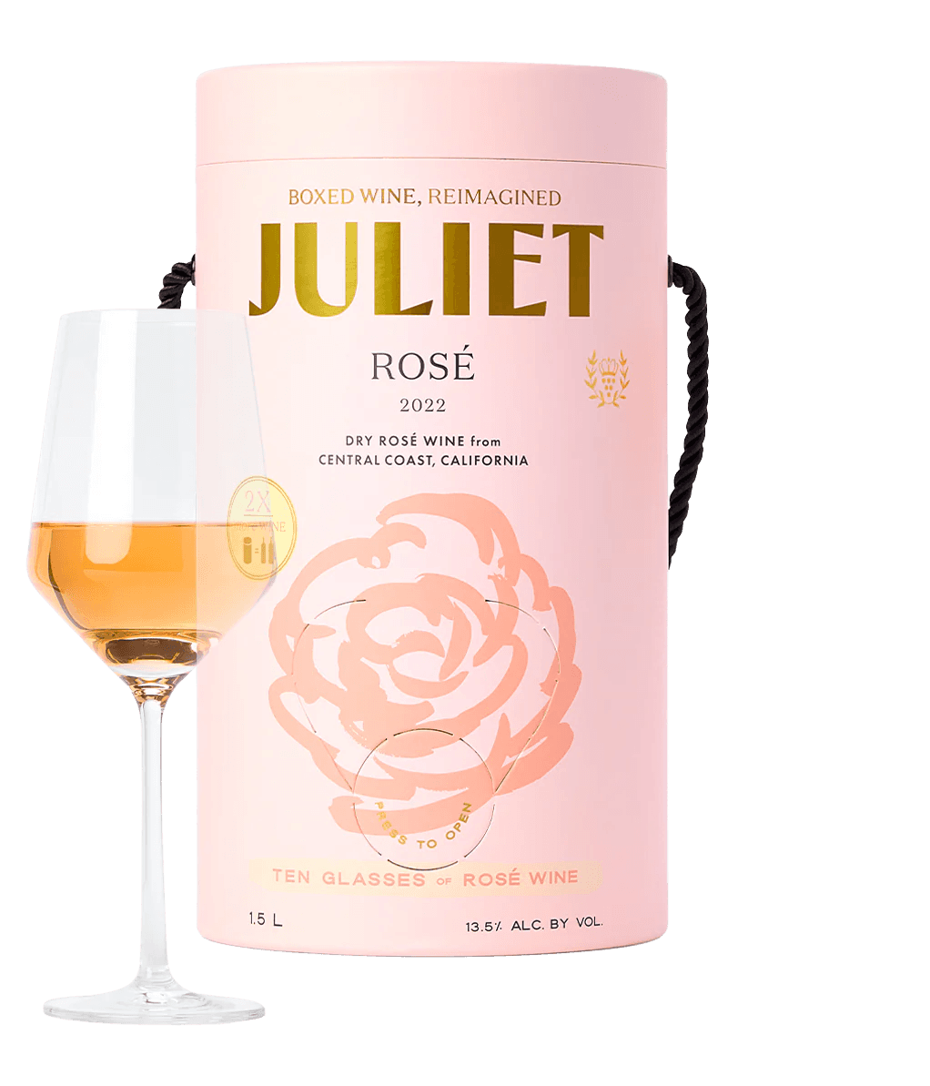 Boxed cylindrical rosé wine with filled glass in front of it.