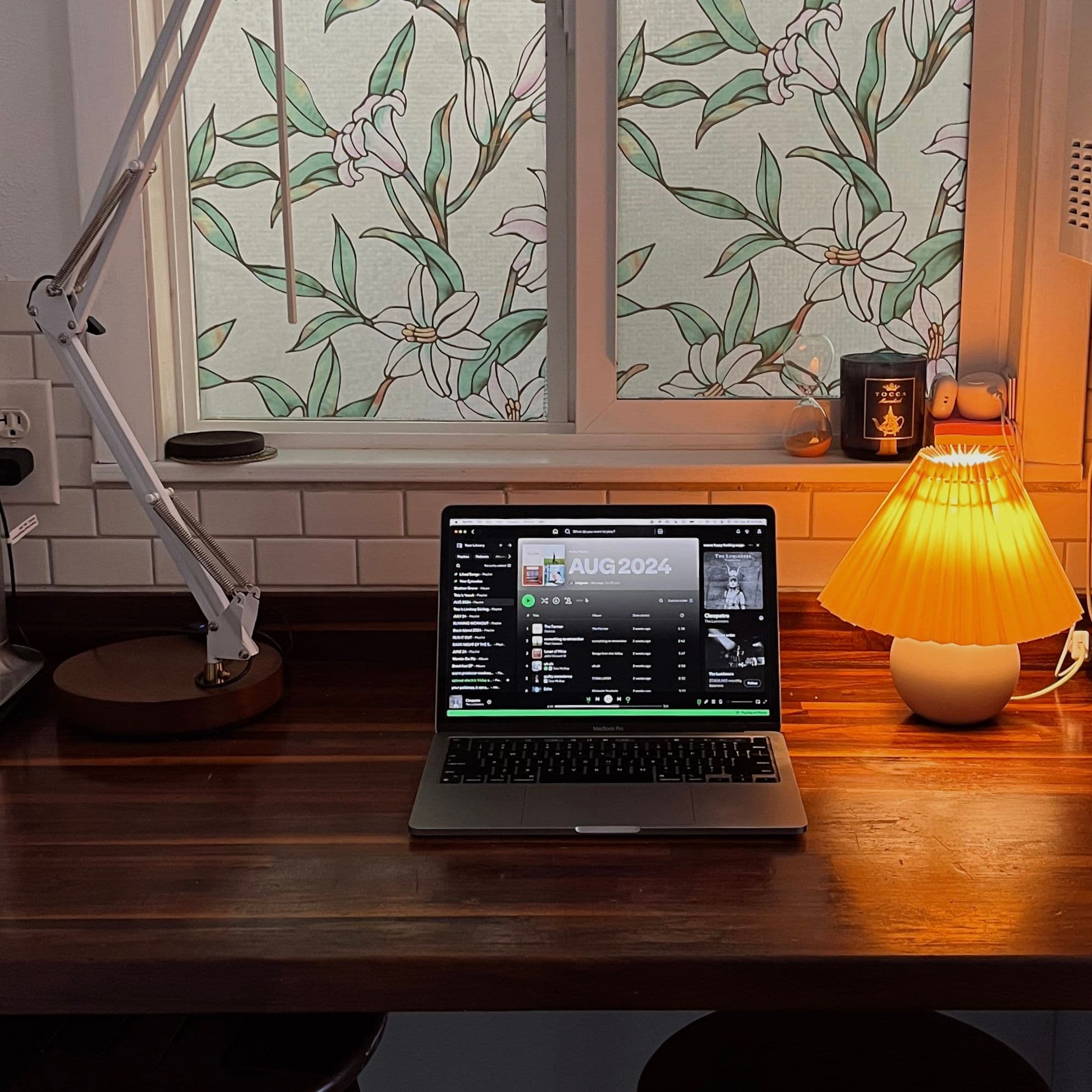 Computer on wooden countertop open to playlist.