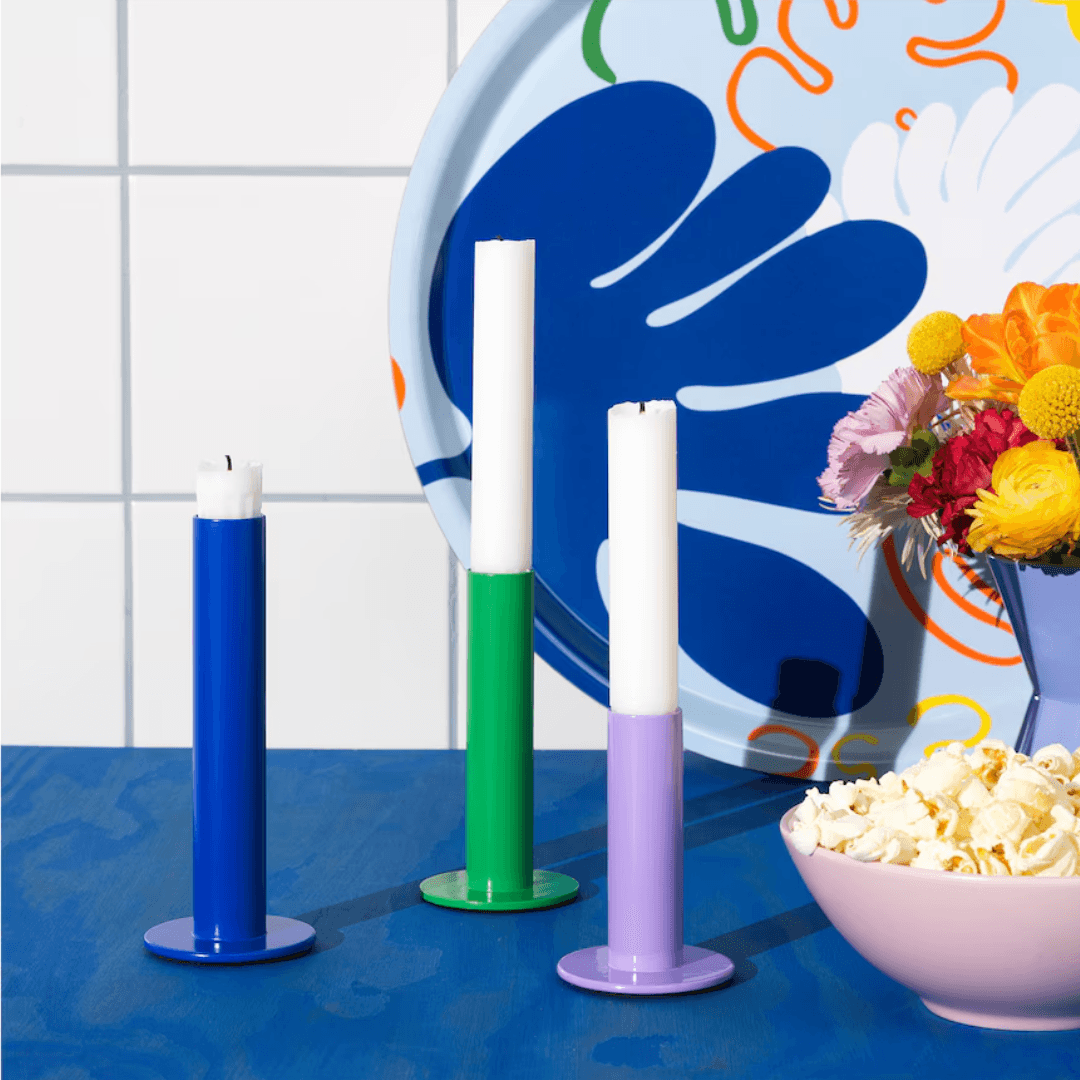 Cobalt, purple, and green candlestick holders styled on a countertop.