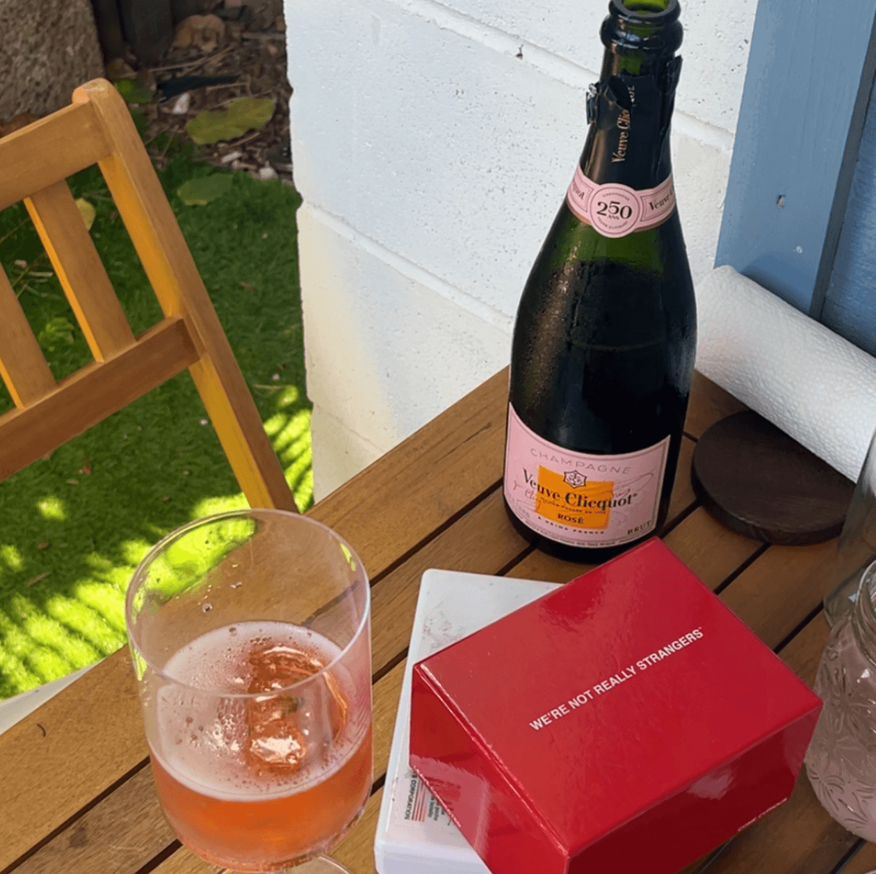 champagne, watercolors, and card game on an outdoor bistro table