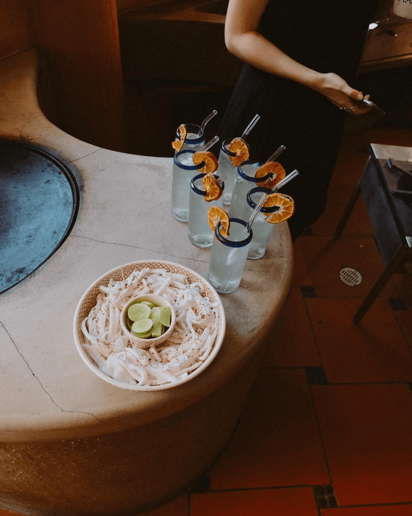 Shaved coconut on a tray with lime with garnished waters beside it.