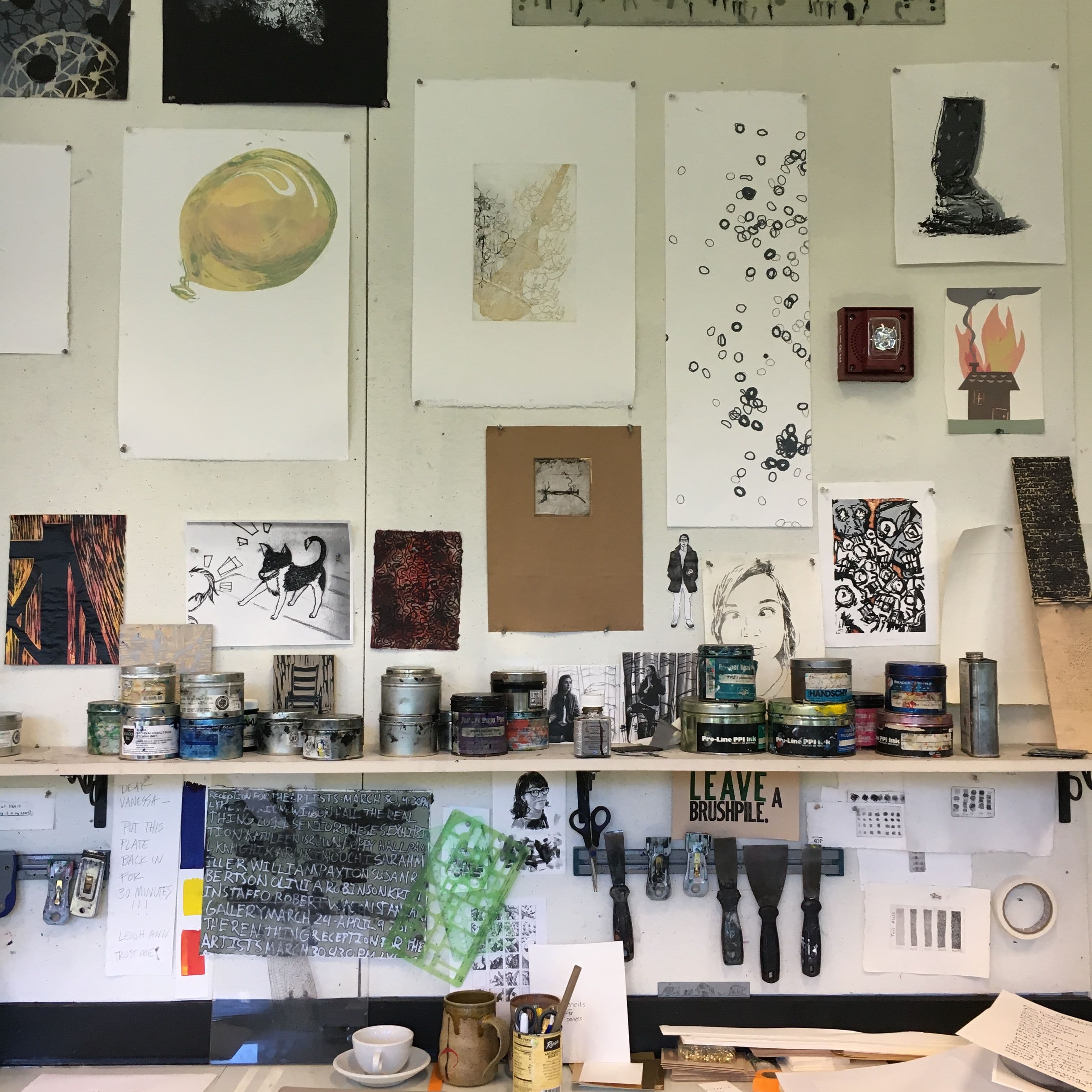 Art studio wall covered in inky prints