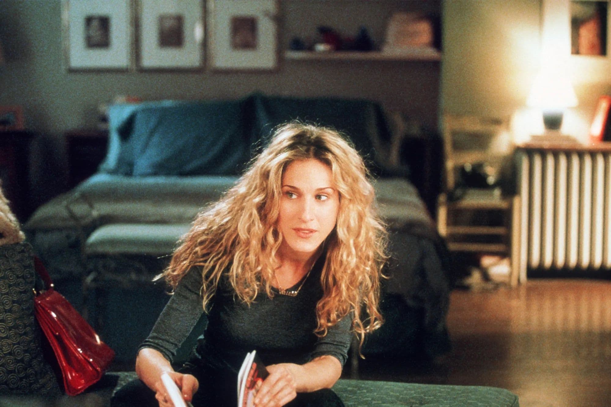 Carrie Bradshaw sitting at desk.