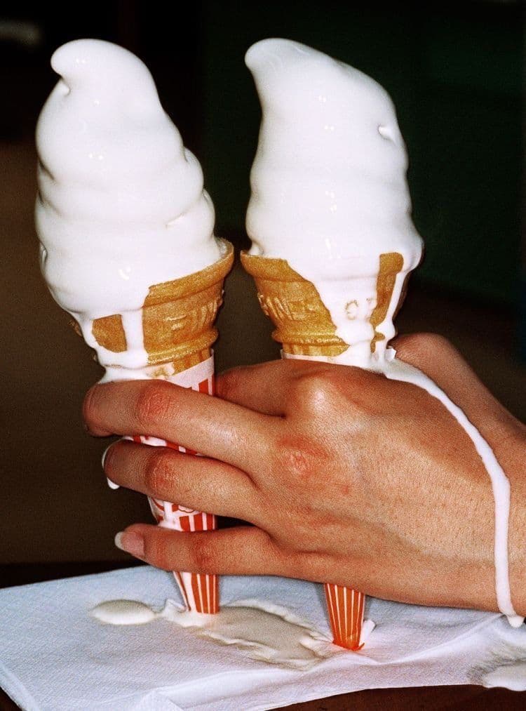 Dripping ice cream cones in one hand